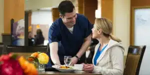 A man serving food to a resident