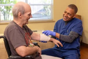 A nurse wrapping a mans bandages at Pine Ridge