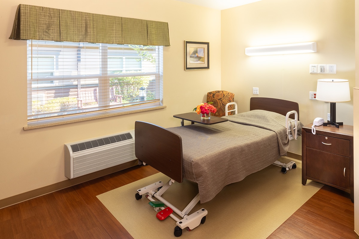 A resident's bedside with a window at Pine Ridge