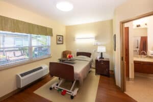 A resident's bed with a window to the right at Pine Ridge