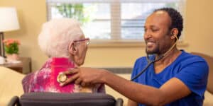 A nurse checking a womans heart beat at Pine Ridge