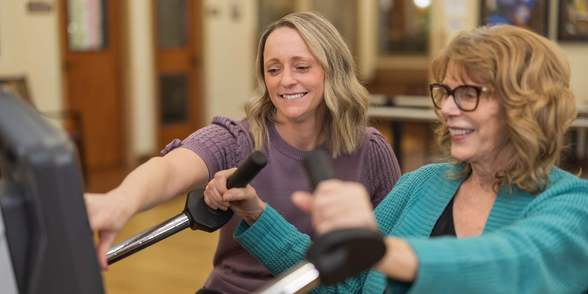 A physical therapist helping a woman do therapy at Pine Ridge